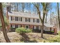 Classic two-story home with brick accents, neutral siding, and manicured landscaping on a sunny, tree-lined lot at 609 Brookview Dr, Chapel Hill, NC 27514