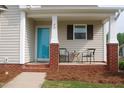 Cozy front porch with brick columns, seating area, and a bright blue front door at 75 E Moss Creek Dr, Clayton, NC 27520