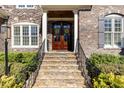 Elegant stone staircase leading to a wood door with sidelights and decorative wreaths at 10016 Porto Fino Ave, Wake Forest, NC 27587
