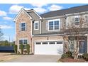 Stylish townhome showcasing a stone and siding exterior with an attached two-car garage at 1029 Benay Rd, Morrisville, NC 27560
