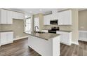 Modern kitchen showcasing an island with a sink, granite countertops, and white cabinetry at 1076 Nc 55, Coats, NC 27521