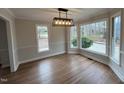 Bright dining area with hardwood floors, large windows, decorative trim, and modern light fixture at 1116 Shadywood Ln, Raleigh, NC 27603