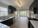 Modern kitchen featuring black cabinets, stainless steel appliances, white countertops, and a view of the dining room at 1116 Shadywood Ln, Raleigh, NC 27603