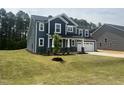 Charming two-story home featuring blue siding, a two-car garage, and a well-maintained lawn at 114 Tee Time Ter, Benson, NC 27504