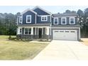 Beautiful two-story home featuring stone accents, a two-car garage, and manicured lawn at 114 Tee Time Ter, Benson, NC 27504