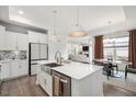 Spacious kitchen featuring white cabinets, stainless steel appliances, island with seating, and an open-concept design at 1206 Linkwood Way, Fuquay Varina, NC 27526
