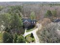 Aerial view showcasing a well-maintained brick home with mature trees and a winding driveway at 12101 Lockhart Ln, Raleigh, NC 27614