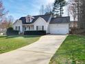 Traditional home with a spacious driveway, attached garage, and well-maintained landscaping at 136 Mayflower Way, Clayton, NC 27527