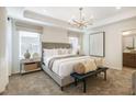 Inviting bedroom boasts a tray ceiling with modern light fixture, and neutral colors throughout at 1411 Chrysalis Pl, Apex, NC 27502