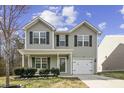 Charming two-story home with gray siding, a covered front porch, attached garage and a well-maintained front yard at 1536 Ricochet Dr, Raleigh, NC 27610