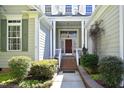 Inviting front entrance with classic brick steps and a covered porch, framed by lush greenery at 1705 Mcrae Pl, Hillsborough, NC 27278