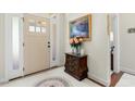 A welcoming foyer with a neutral color palette, decorative rug, and table with fresh flowers at 203 Streamside Dr, Sanford, NC 27330