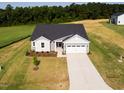 An aerial view of a charming home with an expansive lawn, a two-car garage and long driveway at 207 Golfview Ave, Benson, NC 27504