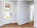 Bright entryway showcasing a white front door, wood-look floors, and neutral wall paint at 207 Golfview Ave, Benson, NC 27504