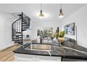 Bright, modern kitchen with a black marble countertop, stainless steel sink, and spiral staircase access at 208 Martin Luther King Jr Blvd, Raleigh, NC 27601