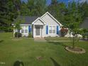 Charming single-story home with blue shutters and a well-manicured front yard featuring mature trees at 225 Sebastian Way, Rocky Mount, NC 27804
