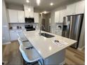 Spacious kitchen featuring white cabinets, stainless steel appliances, and a large center island at 228 Pecan Valley Way, Four Oaks, NC 27524