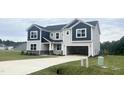 Charming two-story home with blue and gray accents, open garage, and newly laid sod at 245 Golfview Ave, Benson, NC 27504
