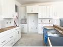 New kitchen showcasing white cabinets and drawers ready for appliances, offering ample storage space at 245 Golfview Ave, Benson, NC 27504