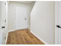 Welcoming entryway showcasing sleek wood flooring, a white front door, and neutral paint at 2527 Girvan Dr, Fuquay Varina, NC 27526