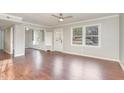 Bright living room featuring built-in shelving, laminate flooring, and a ceiling fan at 2624 Brad Ct, Apex, NC 27539
