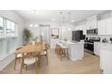 Open concept living with a dining area adjacent to the kitchen island with barstool seating at 2915 Huxley Way, Apex, NC 27502