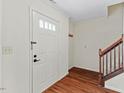 Bright foyer featuring hardwood floors, white trim and a staircase to the upper level at 3207 Coachmans Way, Durham, NC 27705