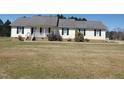 Inviting single-story home with classic facade, covered porch, and manicured front yard at 3226 Powhatan Rd, Clayton, NC 27527