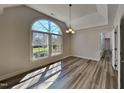 Bright dining room with gray flooring, large window overlooking the yard, and neutral walls creating an open space at 3704 Sky Meadow Dr, Apex, NC 27539
