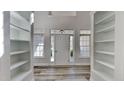 Bright entryway with light gray wood floors, white walls, and symmetrical shelving creating a grand, inviting space at 3704 Sky Meadow Dr, Apex, NC 27539