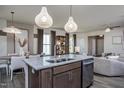 Open-concept kitchen with granite island, pendant lighting, and stainless steel dishwasher, connecting to dining and living areas at 4004 Kidd Pl, Durham, NC 27703
