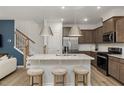 Bright kitchen featuring a spacious island with seating, stainless steel appliances, and dark wood cabinetry at 4008 Kidd Pl, Durham, NC 27703