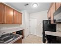 Functional kitchen with wooden cabinets, double sink, and black appliances at 4038 Patriot Ridge Ct, Raleigh, NC 27610