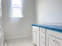 Bathroom with white cabinets, countertop, window and blue protective film at 47 Tee Time Ter, Benson, NC 27504