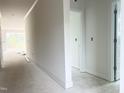 Bright hallway with white walls and trim, leading to a room with large windows at 47 Tee Time Ter, Benson, NC 27504