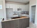 Unfinished kitchen with white cabinets, an island base, and a pantry with shelving at 50 Rainfall Dr, Pittsboro, NC 27312