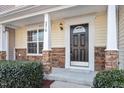 Close-up of the front door featuring detailed trim and stone-accented columns supporting the covered porch at 5210 Blue Lagoon Ln, Raleigh, NC 27610