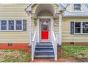 Inviting front entrance featuring a bright red door, white railing, and decorative porch lights at 603 W Main St, Haw River, NC 27258