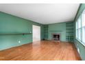 Spacious living room with a fireplace, built-in bookshelves, hardwood floors, and ample natural light at 603 W Main St, Haw River, NC 27258