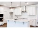 Bright kitchen features a large island, stainless vent hood, white cabinets, and tile backsplash at 63 Tee Time Ter, Benson, NC 27504