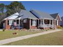 Attractive brick home with a well-manicured lawn, inviting front porch, and charming curb appeal at 703 E Stanley St, Four Oaks, NC 27524