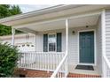 Close-up of front porch with storm door and view of attached garage at 7329 Blannie Farms, Willow Springs, NC 27592