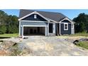 New construction home featuring an attached two-car garage with white painted interior and gravel driveway at 79 Tee Time Ter, Benson, NC 27504