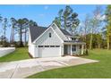 Exterior showcasing a two-car garage, fresh landscaping, and a paved driveway at 8487 Old Us 421, Lillington, NC 27546