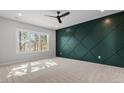Spacious bedroom features a decorative accent wall, neutral carpet, bright picture window, and a ceiling fan at 934 Woodland Rd, Creedmoor, NC 27522
