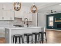 Modern kitchen featuring white cabinets, stainless steel appliances, and a large island with seating at 934 Woodland Rd, Creedmoor, NC 27522