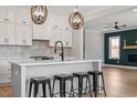 Bright kitchen featuring white cabinets, quartz countertops, black hardware and a view into the Gathering room at 934 Woodland Rd, Creedmoor, NC 27522