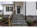Close-up of the front entrance with stone steps and wood railing, showcasing quality craftsmanship at 9600 Stallings Rd, Spring Hope, NC 27882