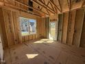 Framed interior view of subfloor, stud walls and door with natural light from the window and door at 9600 Stallings Rd, Spring Hope, NC 27882