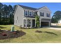 Charming two-story home showcasing a neutral color scheme, with landscaped front yard, and a two-car garage at 98 Tee Time Ter, Benson, NC 27504